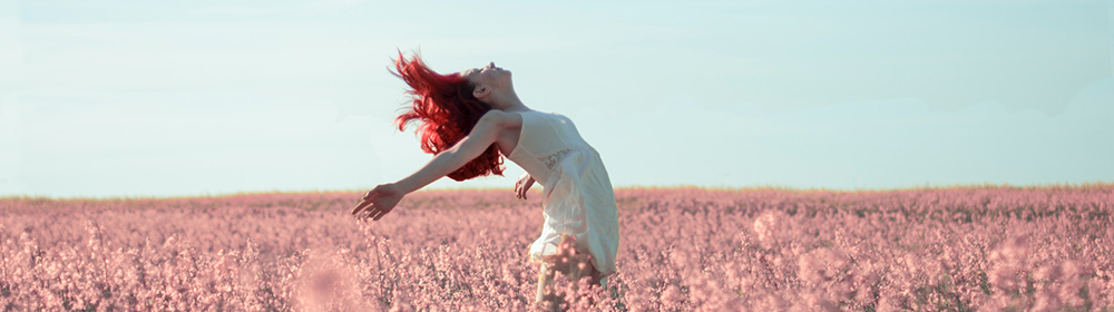 Imagen de una mujer en un campo de color rosa